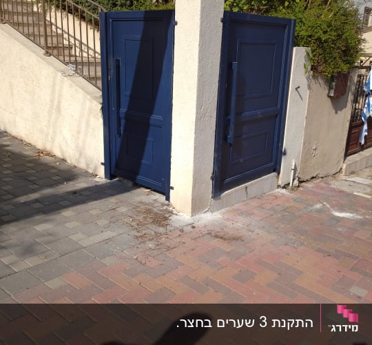 שני שערים כחולים פתוחים על עמוד בטון